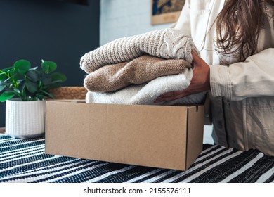 Woman holding Clothes with Donate Box In her room, Donation Concept. - Shutterstock ID 2155576111