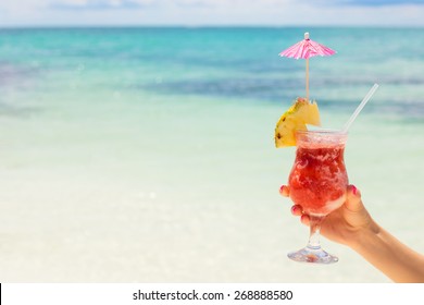 Woman Holding Cocktail On Tropical Beach