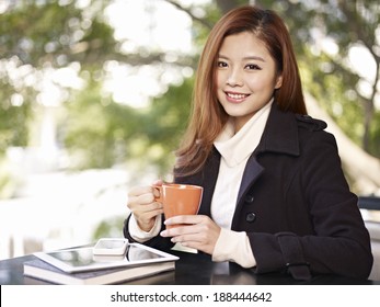 woman holding coffee cup looking at camera smiling - Powered by Shutterstock