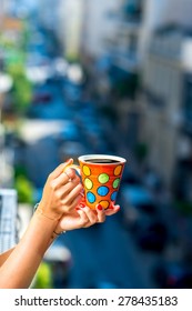 Woman Holding Colorful Coffee Cup On Blured City Street Background. 