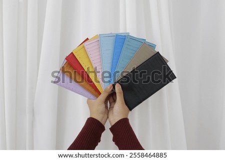 Similar – Image, Stock Photo Woman holding colorful wallets against yellow background