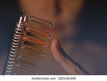 Woman holding a comb tube of High Frequency D'arsonval Device producing micro current. Hair micro current therapy. Hair care, hair treatment. High frequency electrotherapy. Photo of D'arsonval Comb.