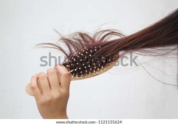 Woman holding combing with brush and clean long\
hair, Haircare concept