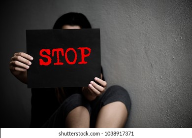 A woman holding a conceptual stop sign on violence against women. Womens day and Human Rights Day concept.