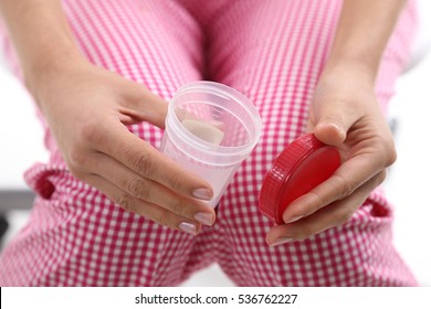 Woman Holding Container Of Urine Sample Cup