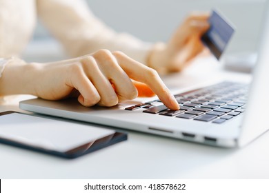 Woman Holding Credit Card In Hand And Entering Security Code Using Laptop Keyboard, Photo With Depth Of Field