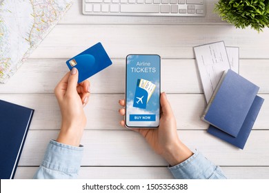 Woman Holding Credit Card And Smartphone Buying Plane Tickets Online, Top View