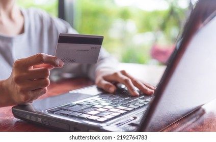 Woman Holding A Credit Card And Typing Information On A Keyboard Laptop.online Shopping Concept, E-Commerce, Internet Payments, Financial Security.