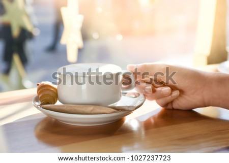 Similar – Foto Bild Frau Hand, die eine Tasse Kaffee von einem Holztisch im Garten aufzieht.