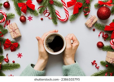 Woman holding cup of coffee. Woman hands holding a mug with hot coffee. Winter and Christmas time concept. - Shutterstock ID 2386103795