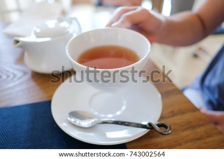 Woman holding a cup of hot tea drinking