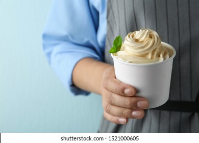 Woman Holding Cup With Tasty Frozen Yogurt On Blue Background, Closeup