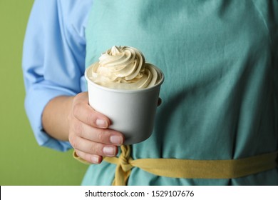 Woman Holding Cup With Tasty Frozen Yogurt On Green Background, Closeup