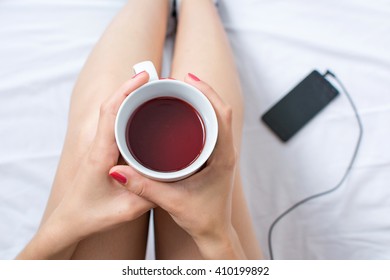 Woman Holding A Cup Of Tea In Bed