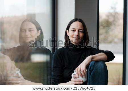 Similar – laughing twin sisters in front of the wall with red and blue green coat