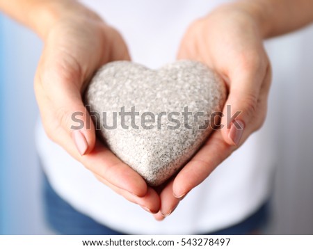 Woman holding decorative heart in hands, closeup
