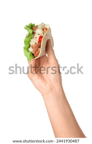 Woman holding delicious taco with meat and vegetables on white background, closeup