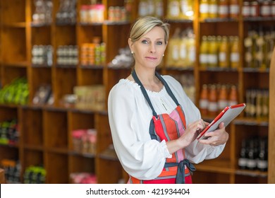 Woman Holding Digital Tablet In Grocery Store - Powered by Shutterstock