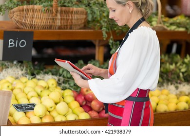 Woman Holding Digital Tablet In Grocery Store - Powered by Shutterstock