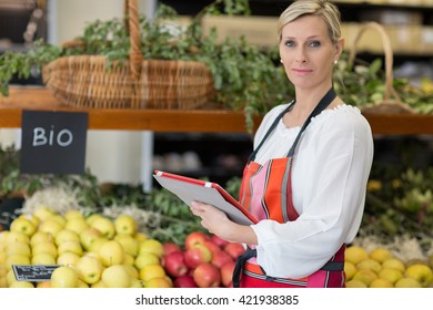 Woman Holding Digital Tablet In Grocery Store - Powered by Shutterstock