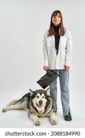 Woman Holding Dog Cleaning Package Near Her Siberian Husky Dog. Concept Of Pet Care. Idea Of Dog Hygiene. Smiling European Girl Looking At Camera. Isolated On White Background In Studio. Copy Space