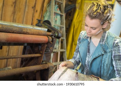 woman holding dried fish skins by wringer
