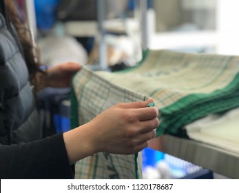 Woman Holding  Dried And  Folding  Dish Towel In Laundry Shop.