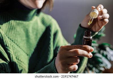 Woman Holding A Dropper Of Sublingual Cbd Cannabis Hemp Oil - Alternative Medical Treatment