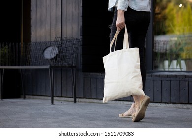 Woman Holding An Eco Bag. Ecology Or Environment Protection Concept. White Eco Bag For Mock Up.