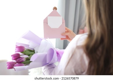 Woman Holding Envelope With Blank Greeting Card And Tulip Bouquet At Home.