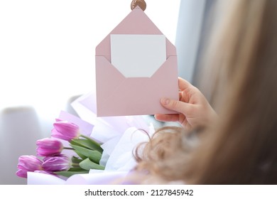 Woman Holding Envelope With Blank Greeting Card And Tulip Bouquet At Home.