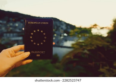 Woman holding EU passport against the backdrop of a tropical country. - Shutterstock ID 2282523747