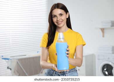 Woman holding fabric softener in bathroom, space for text - Shutterstock ID 2310735215