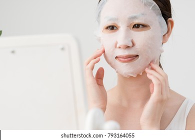 
A Woman Holding A Face Mask, A Mirror