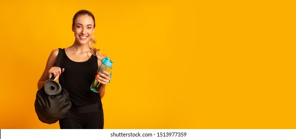 Woman Holding Fitness Bag, Rolling Mat And Water Ready For Training. Yellow Background, Studio Shot, Panorama With Free Space - Powered by Shutterstock