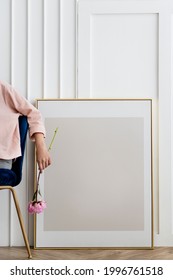 Woman holding a flower sitting by a frame mockup