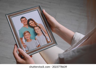 Woman Holding Framed Family Photo Indoors, Closeup