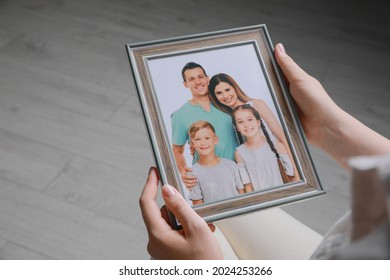 Woman Holding Framed Family Photo Indoors, Closeup