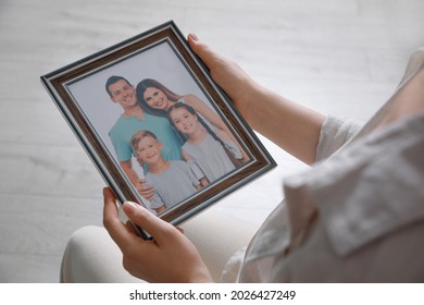 Woman Holding Framed Family Photo Indoors, Closeup