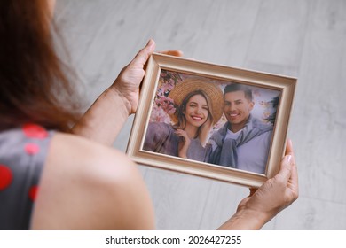 Woman Holding Framed Photo Of Happy Couple Indoors, Closeup