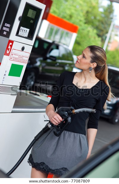woman holding fuel\
nozzle in gas station