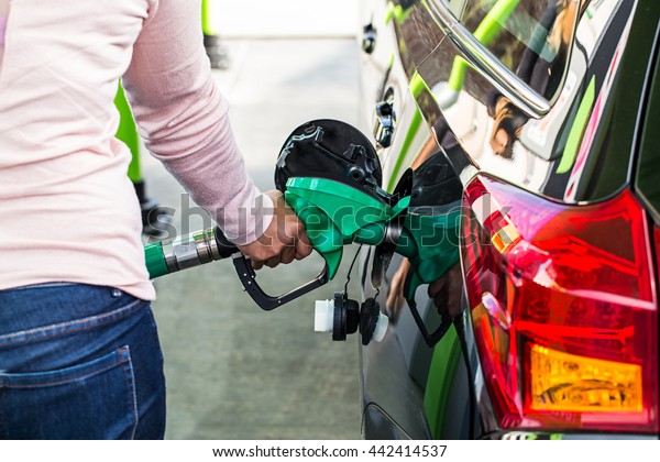 woman holding fuel pump\
in gas station.
