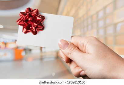 Woman Holding Gift Card In A Restaurant Or Shop