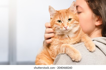 Woman Holding A Ginger Cat In Her Arms