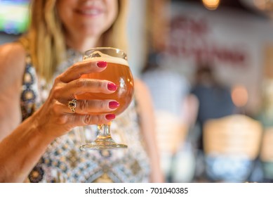 Woman Holding A Glass Of Beer In Tap Room At Chicago Microbrewery - Soft Focus