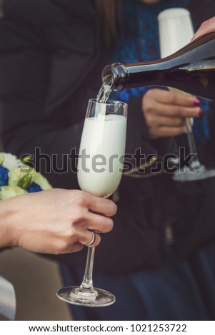 Woman holding a glass of champagne. Bride. Wedding dress. Close up picture.