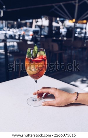 Woman is holding a glass of cocktail, summer days