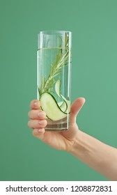 Woman Holding Glass Of Fresh Cucumber Water On Color Background