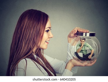 Woman Holding A Glass Jar With Imprisoned Man In It