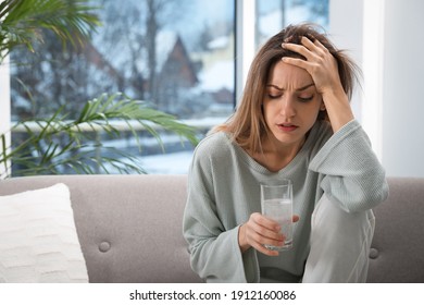 Woman Holding Glass Of Medicine For Hangover At Home